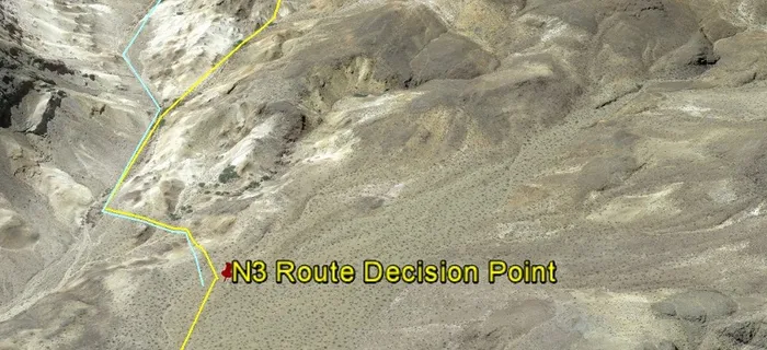 The wash veers to the right (from the marker) and ends in a hilly area, going straight requires descent to Canyon.